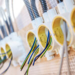 Electrical Outlets Mounted on a Wall With Colorful Wiring Connections